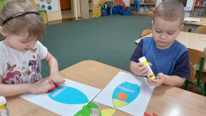 Julcia i Igor wykonują rakietę z gotowych papierowych figur geometrycznych.