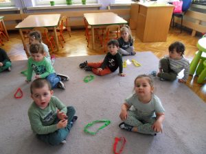 Bartuś, Julia, Tymek Bo., Adaś G.,Karol, Kalinka i Ala układają z pasków bibuły kropelki na dywanie.