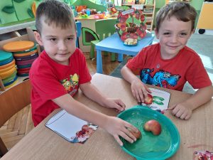 Mikołaj i Oskar stemplują jabłkami.