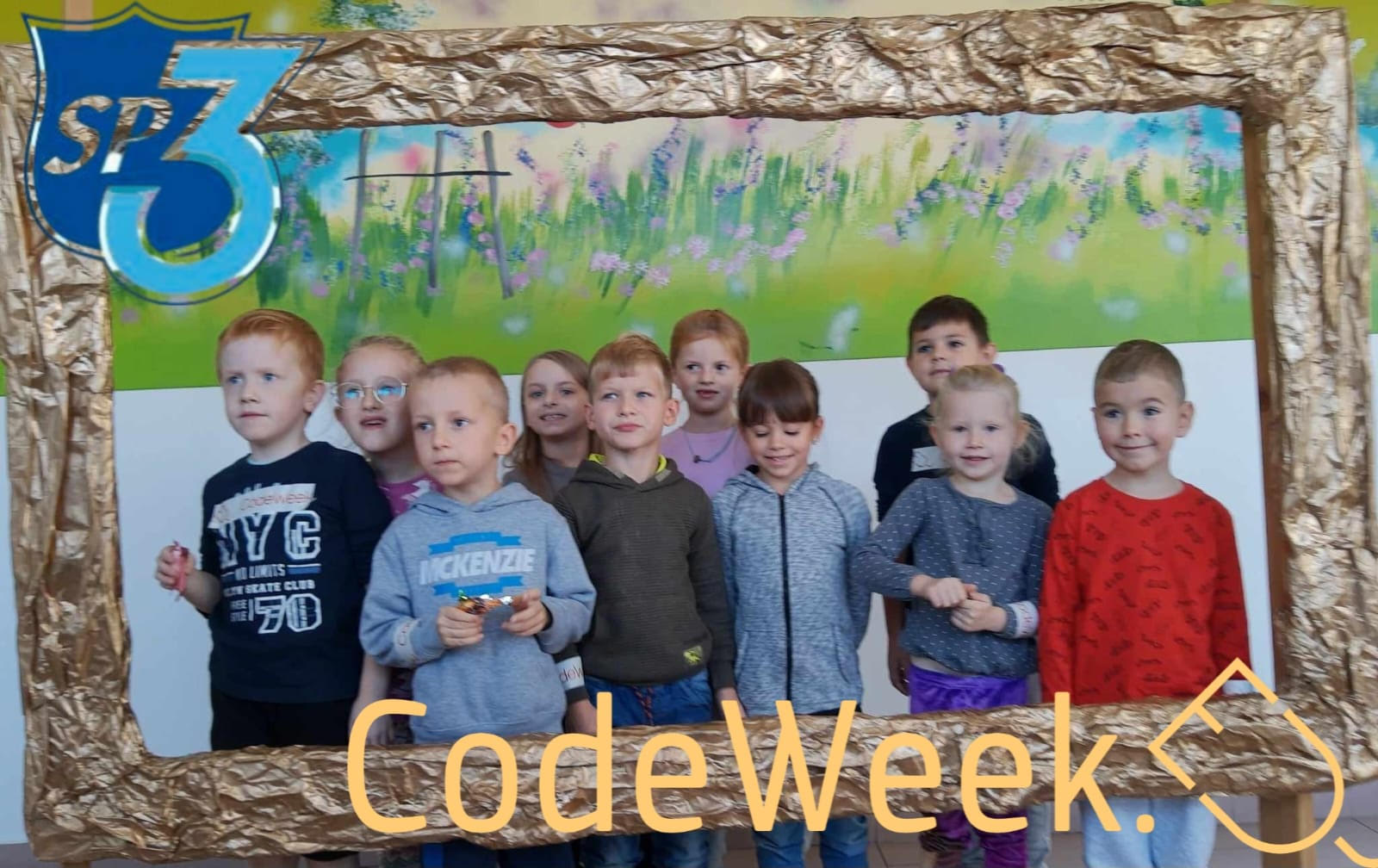 Dzieci pozują do wspólnego zdjęcia w ramach Europejskiego Dnia Kodowania.