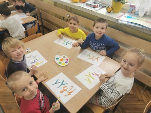 Dzieci wypełniają kontury litery y, Y za pomocą rurki i farb