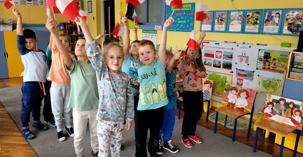 Dzieci prezentują biało-czerwone flagi.