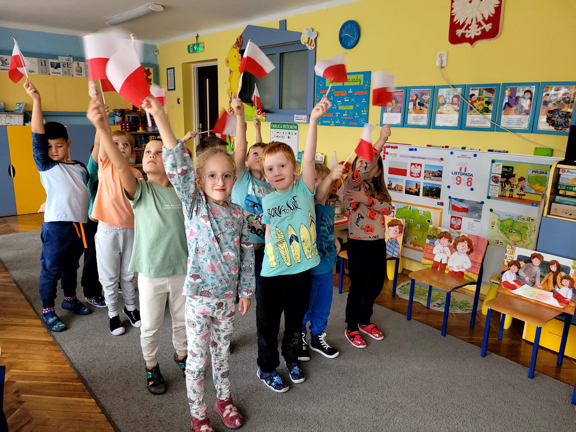 Dzieci prezentują biało-czerwone flagi.