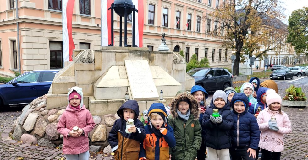 Przedszkolaki pozują do zdjęcia przy pomniku Nieznanego Żołnierza.