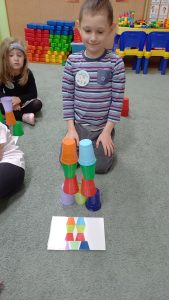 Filip prezentuje swoją wieże z kolorowych kubeczków.