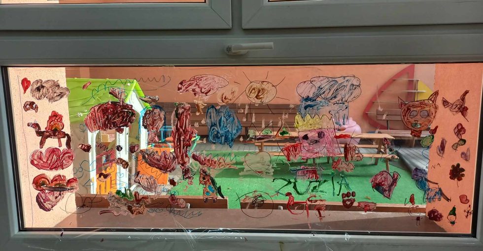 Okno przedstawiające rysunki dzieci, namalowane w ramach projektu "Zabawa ze sztuką"