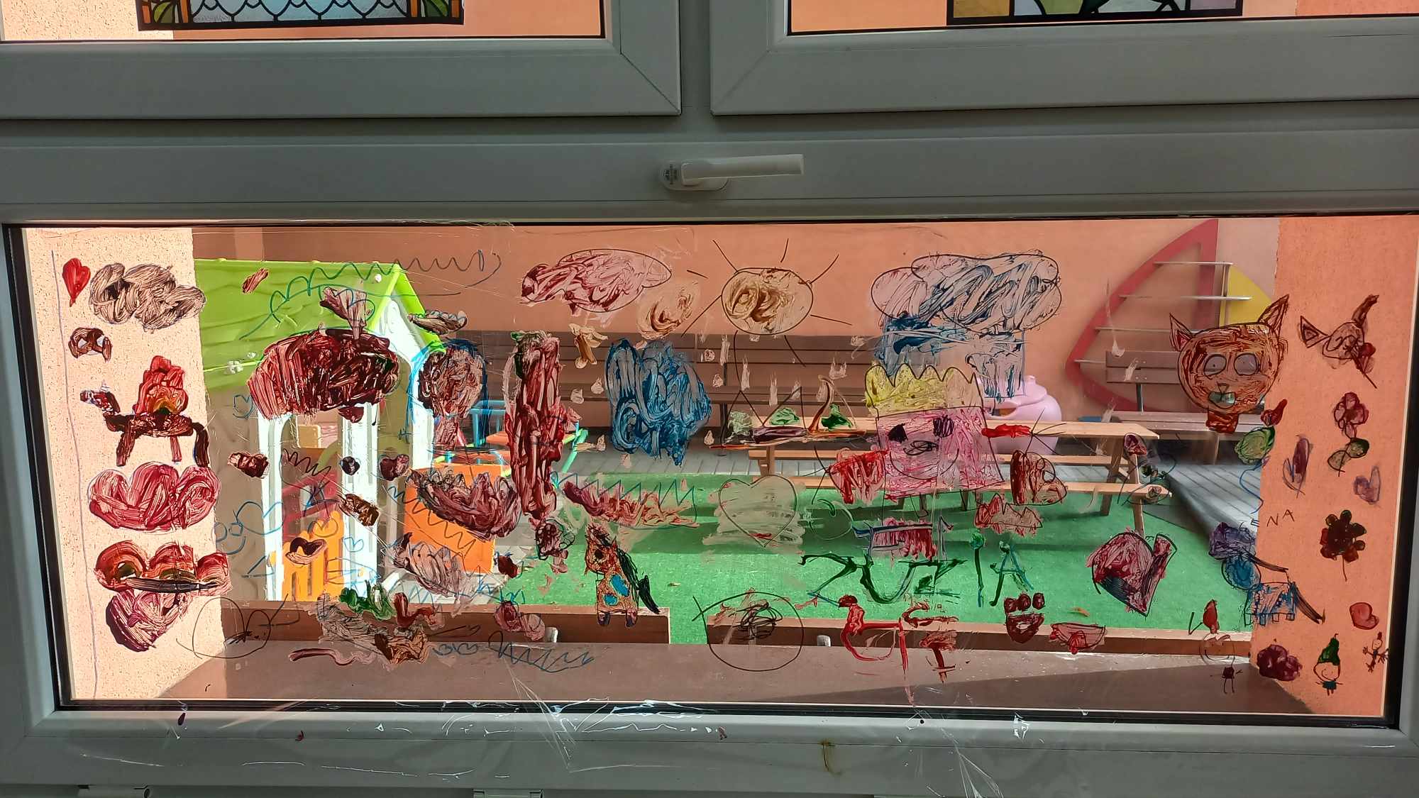 Okno przedstawiające rysunki dzieci, namalowane w ramach projektu "Zabawa ze sztuką"