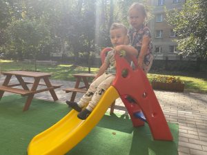 Chłopiec i dziewczynka zjeżdżają ze zjeżdżalni