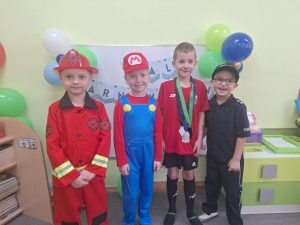 Czworo chłopców pozuje do zdjęcia w przebraniach karnawałowych.