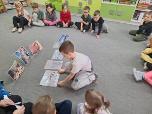 Chłopiec wskazuje ilustrację z zimowym pejzażem.