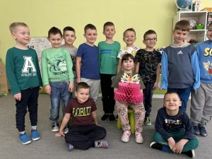 Solenizantka pozuje do zdjęcia z kolegami z grupy.