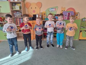Chłopcy pozują do zdjęcia trzymając upominki od koleżanek.