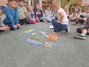 Chłopiec wybiera obrazek z daną porą roku.