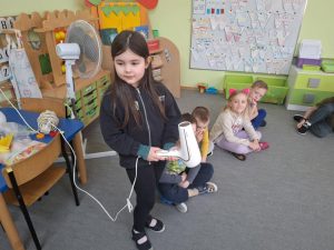 Dziewczynka trzyma suszarkę do włosów.