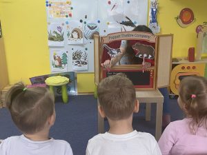 dzieci oglądają mini teatrzyk przygotowany przez nauczycielkę , w roli głównej występują zwierzę†a , które obudziły się z zimowego snu (trzymane na patykach przez nauczycielkę) 
