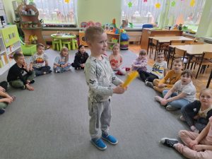 Chłopiec trzyma papierowy wachlarz.