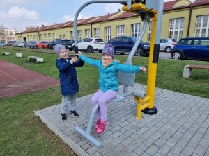 Dzieci ćwiczą na siłowni plenerowej.