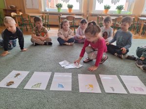 Dziewczynka wybiera obrazek z oznaką wiosny.