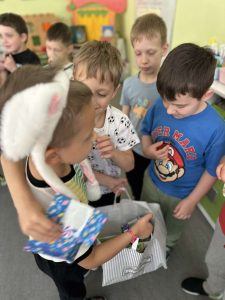 Dwójka chłopców składa życzenia solenizantowi i częstuje się słodkościami urodzinowymi.