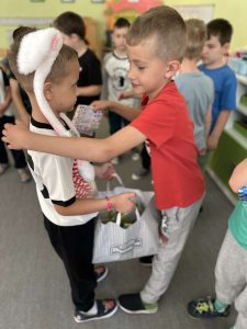 Dwóch chłopców. Jeden składa życzenia solenizantowi w dniu jego urodzin.