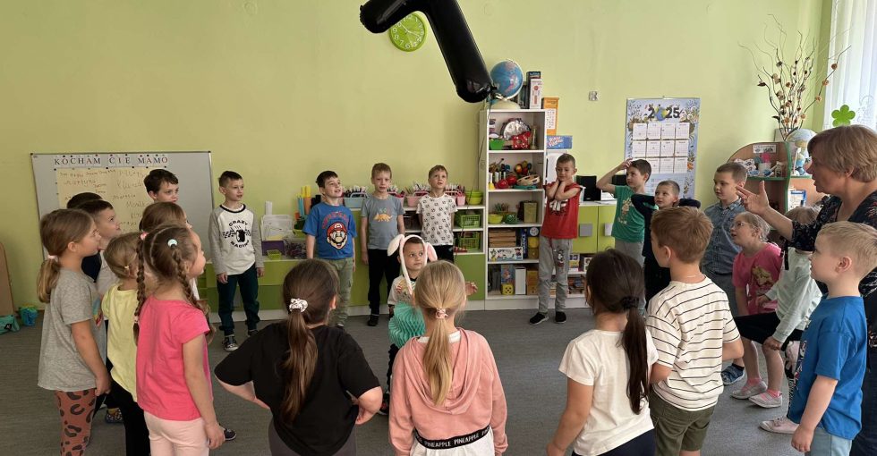 Solenizant siedzi w środku koła. Wokół rówieśnicy z grupy, śpiewają sto lat.